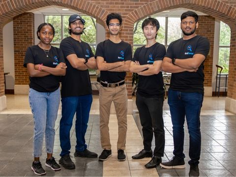 medreveal-team Five members of the med reveal team stand in a row with their arms folded, wearing matching t-shirts.