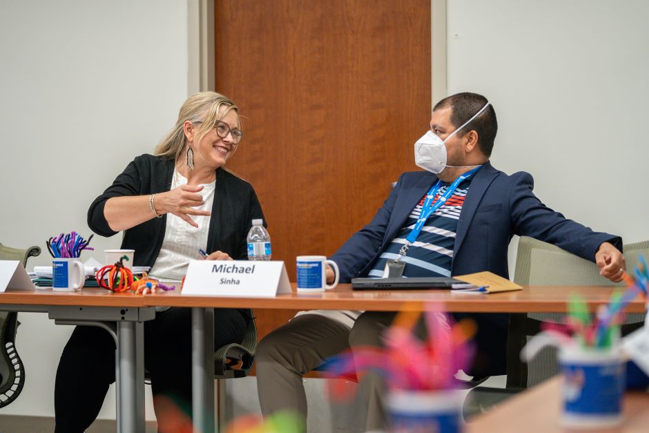 Profs. Sinha and Gillespie speak at a table at the Health Law Scholars Weekend