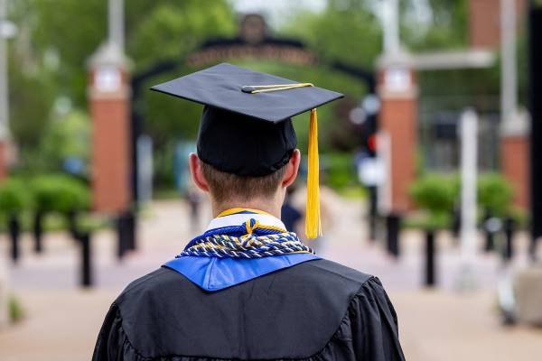 View from back of graduate dressed in gown and mortarboard