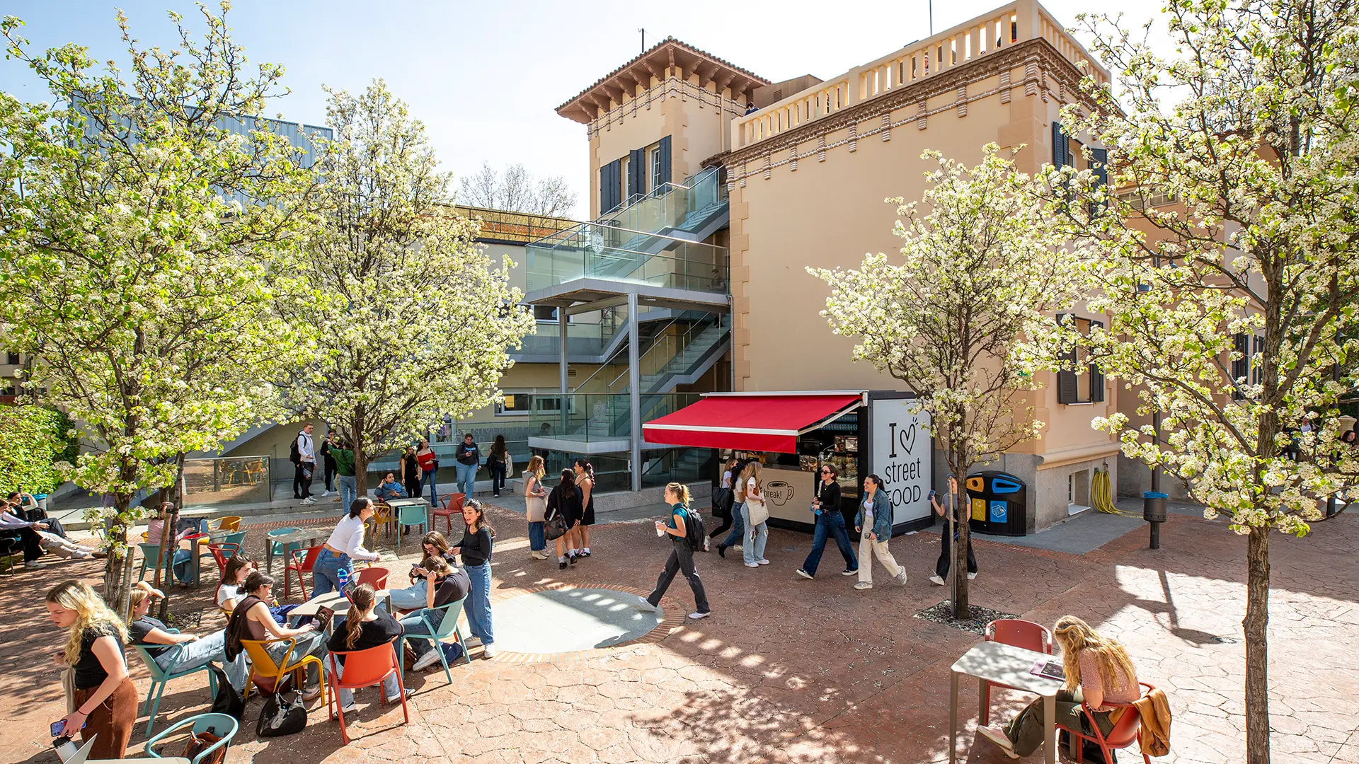 A picture of Padre Rubio Hall's patio, one of the university's buildings, with students casually chatting and relaxing with each other.