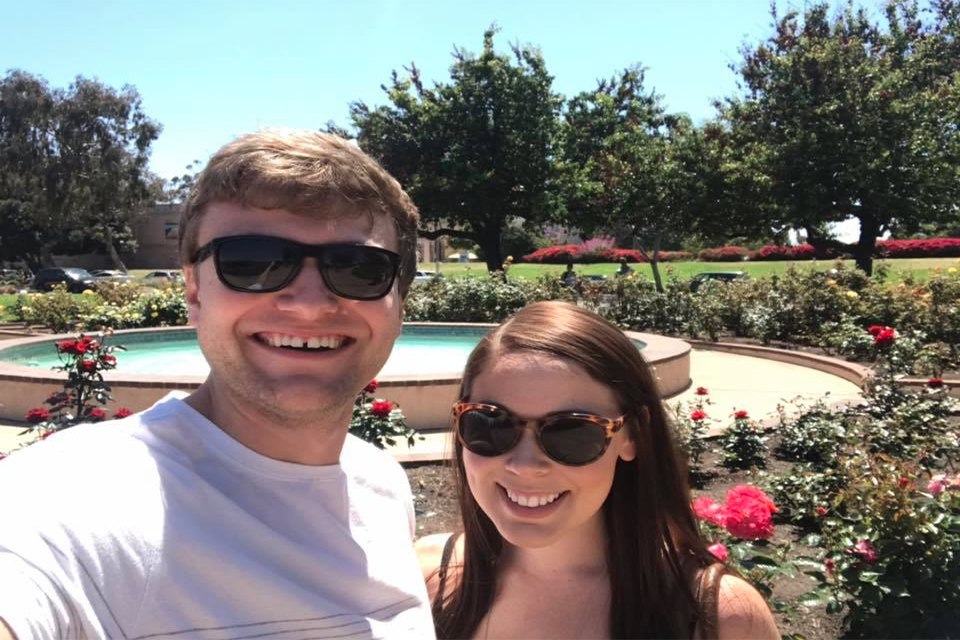 Daniel standing in a garden with a friend wearing sunglasses.