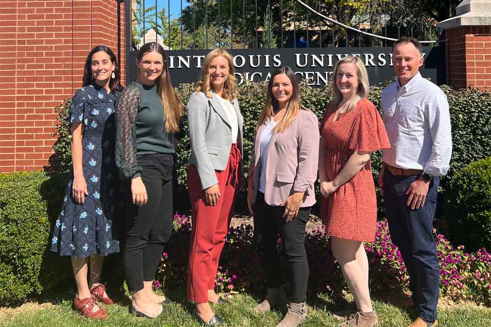 Group photo of adult neuropsychology fellows standing in front of medical center sign