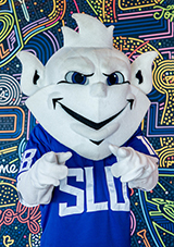 Billiken mascot in front of a graffiti wall