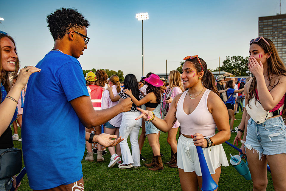 Students competing in rock, paper, scissors in Hermann Stadium