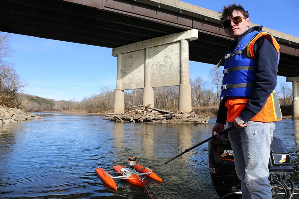 A WATER Institute student at a site visit near a Missouri bridge